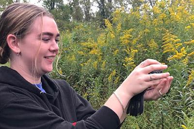 A student holds a bird.