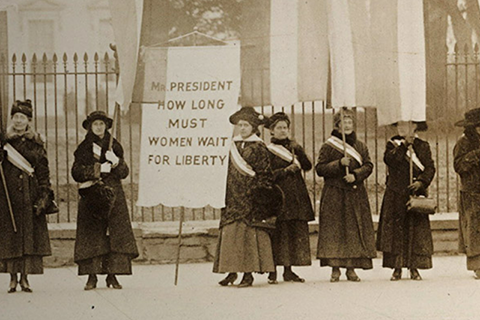 black and white photo from 1917 of women picketing outside the White House demanding voting rights and equality