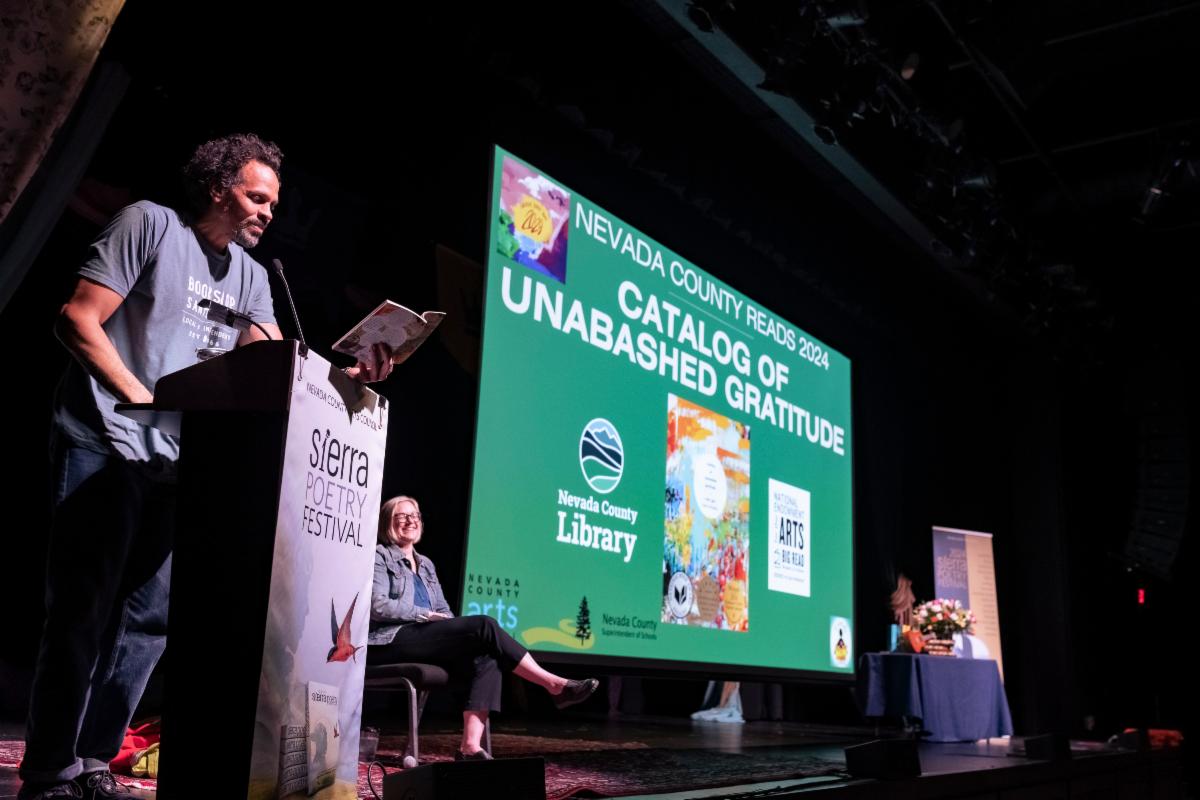 Ross Gay reads from his Nevada County Reads book "Catalog of Unabashed Gratitude" at the Sierra Poetry Festival on Apr. 13 (pictured with Nevada County Youth Services Librarian Tricia Caspers-Ross) Photo by Casey Garrotto