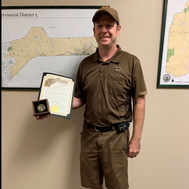 UPS driver Roy Lewis holds certificate of recognition for helping prevent spread of fire south of North San Juan Aug. 17. 