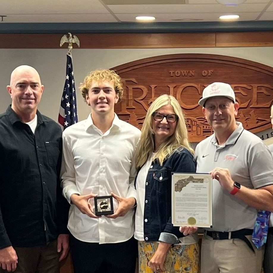 Four people in the Truckee Town Chambers holding an award