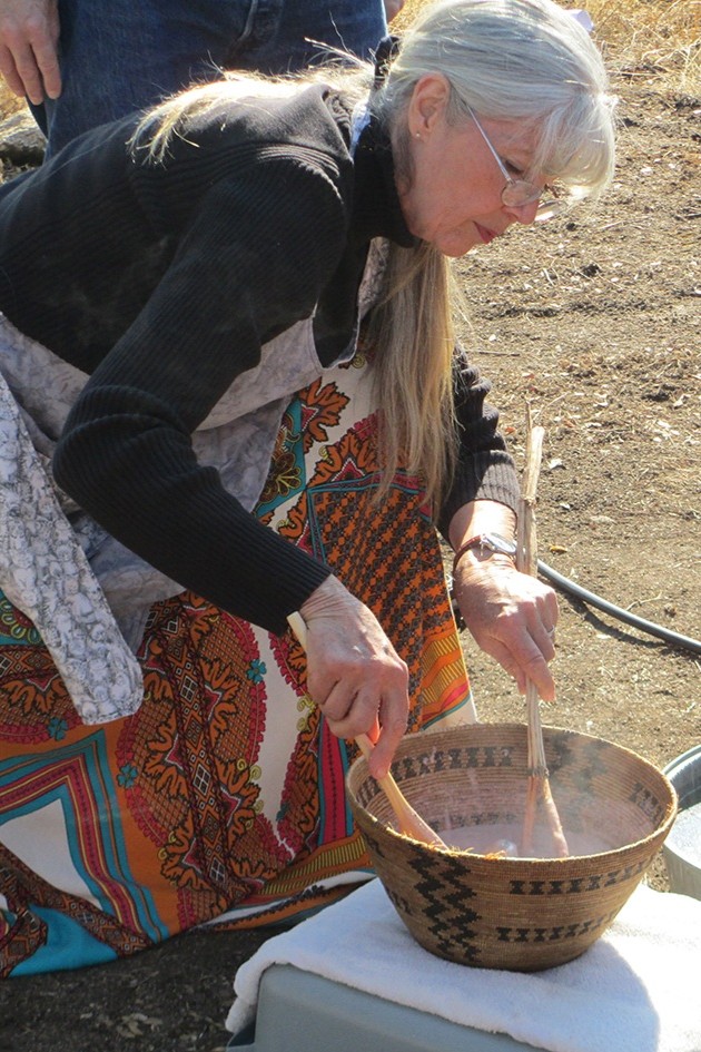 Woman demonstrates how acorns are prepared and cooked in handwoven basket