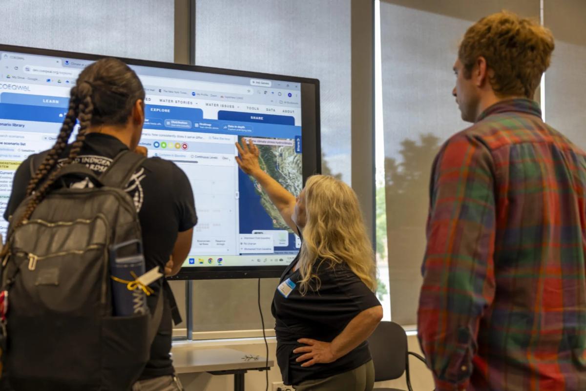 Attendees of the COEQWAL launch event demo the new website on large touchscreen displays