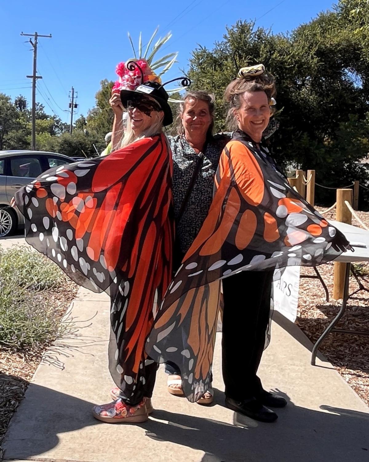UC Master Gardener volunteers dressed in monarch butterfly costumes pose in a new pollinator garden during a ribbon-cutting event