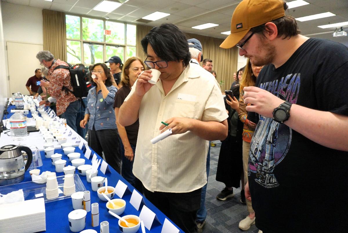 Two Tea Day participants place their noses into their cups to get the aroma of the tea during a tasting activity