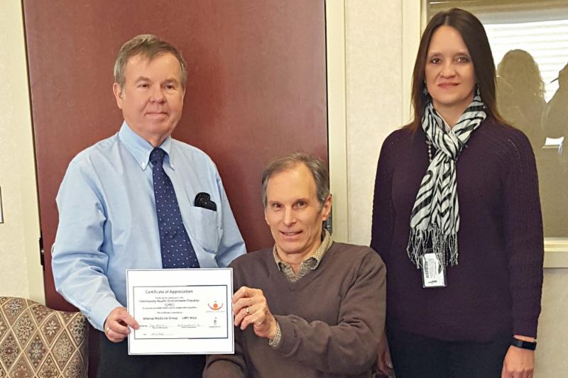 Bob Mikesic presenting CHEC certificate of appreciate to Dr. Gregory Schnose and Emily Herman