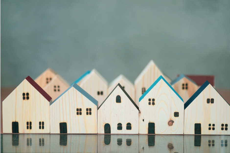 image of wooden block style houses with painted rooftops aligned close together to depict a neighborhood