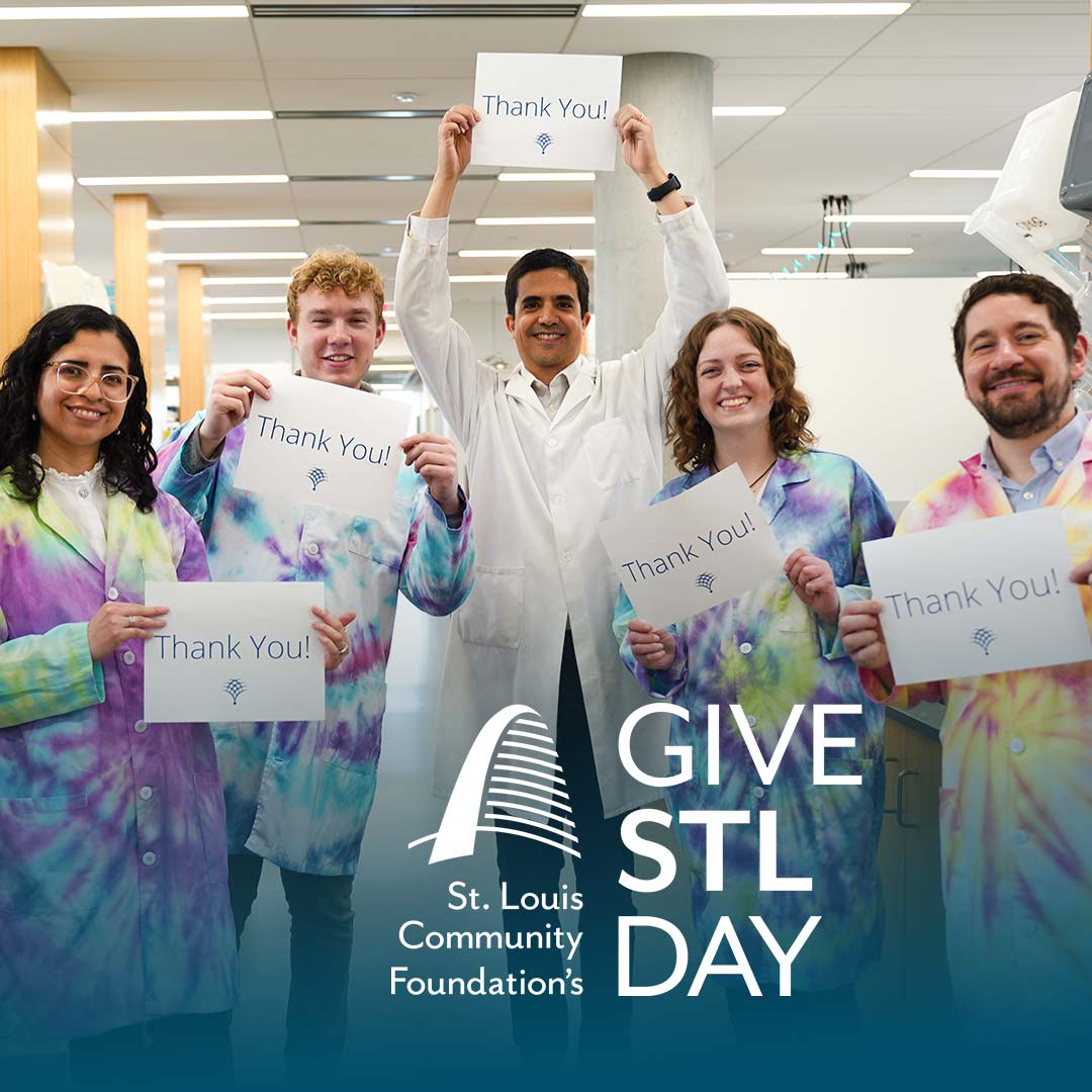 Members of the Bravo lab holding thank you signs. The Give STL Day logo below.