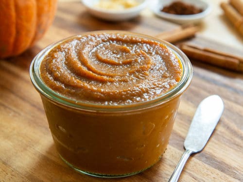 Jar of pumpkin butter sitting on a wooden table