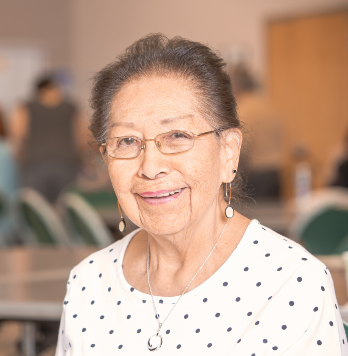 An older woman smiling and looking at the camera.