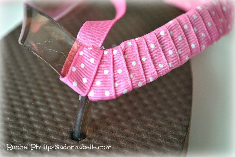 Brown flip flop sandal partially decorated with pink ribbon