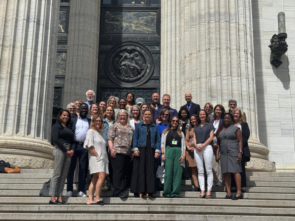 group of collaboration council members posing on the steps of the education building
