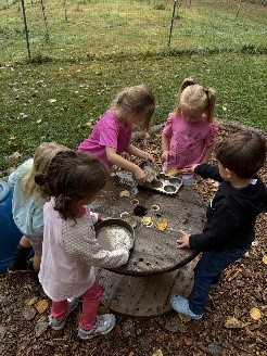 PreK students working in the Mud Kitchen