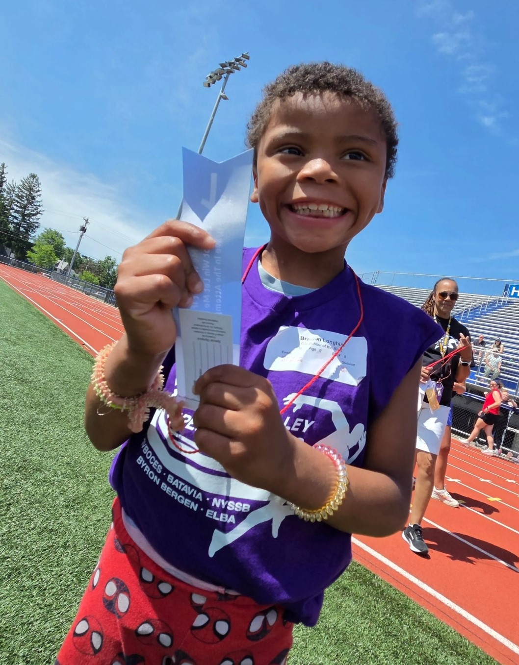 Special Olympic student smiling and holding badge