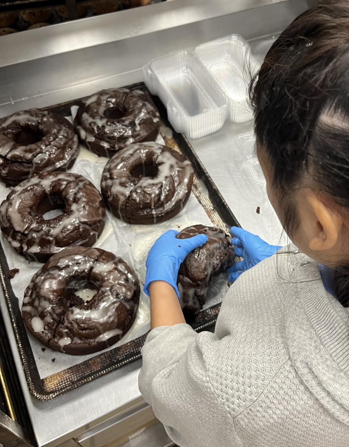 Student frosting donuts