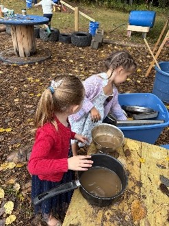PreK students working in the Mud Kitchen