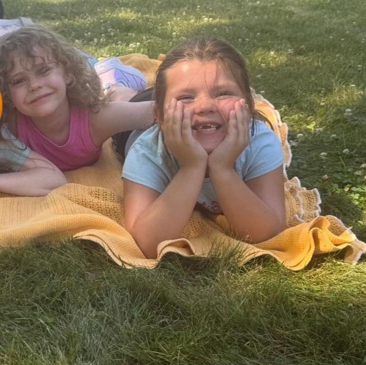Students lying on the grass smiling