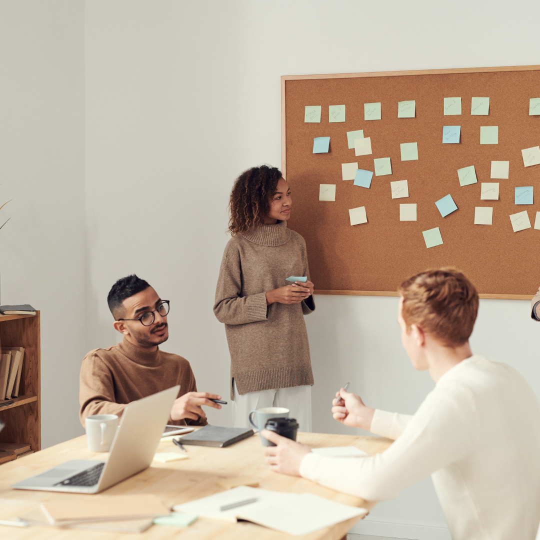 Team of people meeting in shared workspace.