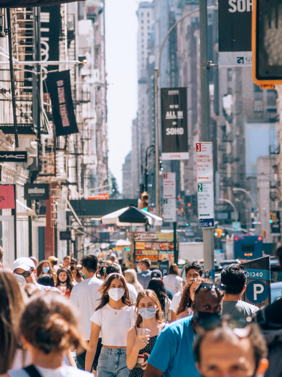 People wearing face masks while walking through the city. Photo by Yoav Aziz on Unsplash.