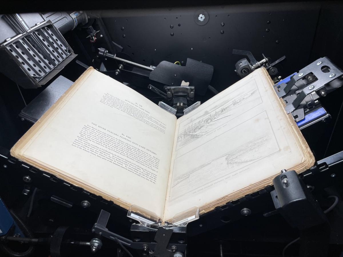 The book Forty etchings from sketches made with the camera lucida - in North America - in 1827 and 1828 resting safely in the cradle of a book scanner at the NYS Library