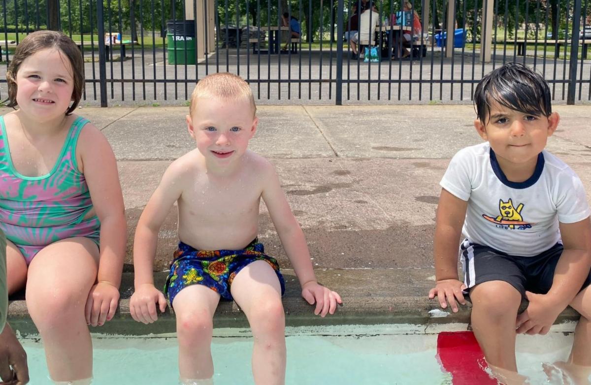Students sitting by the pool