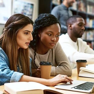Two young adults working collaboratively on a laptop