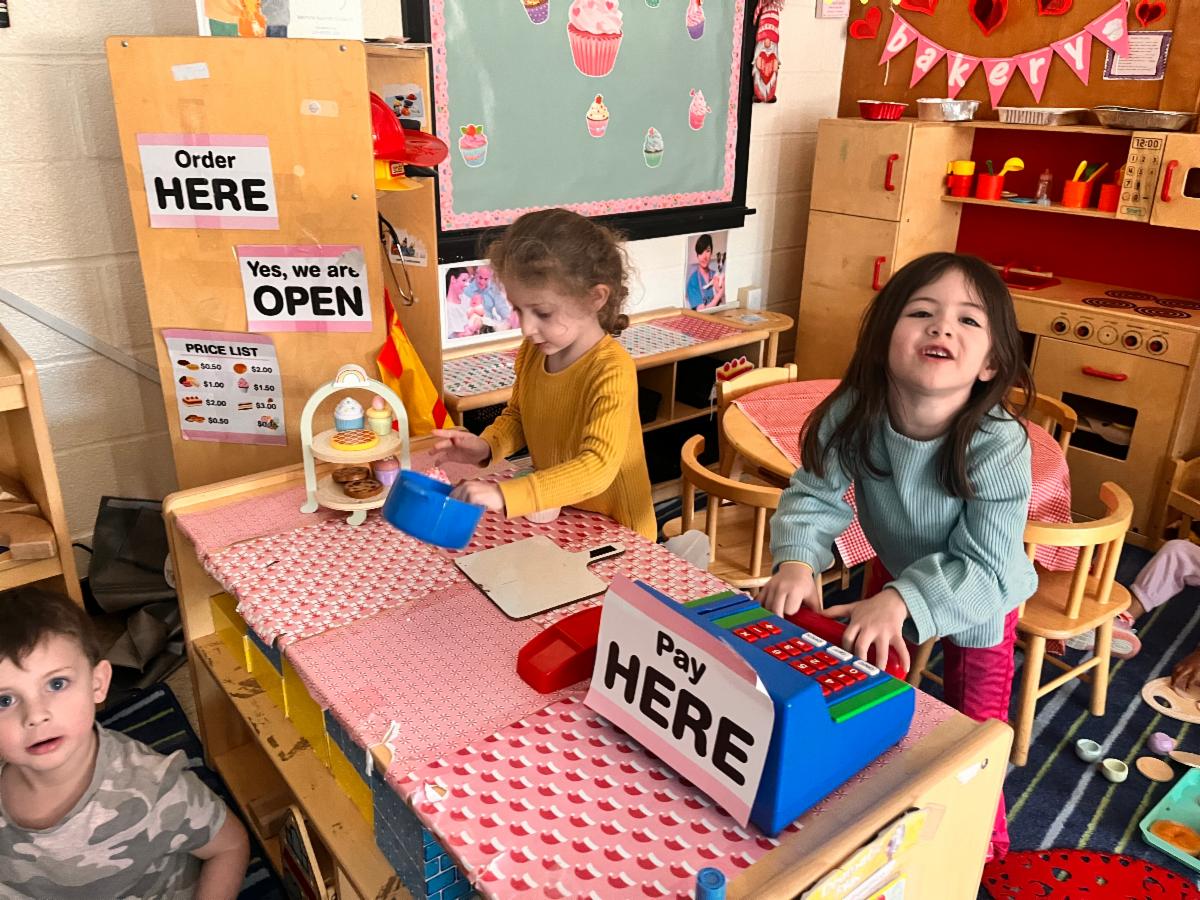 children playing in a pretend kitchen