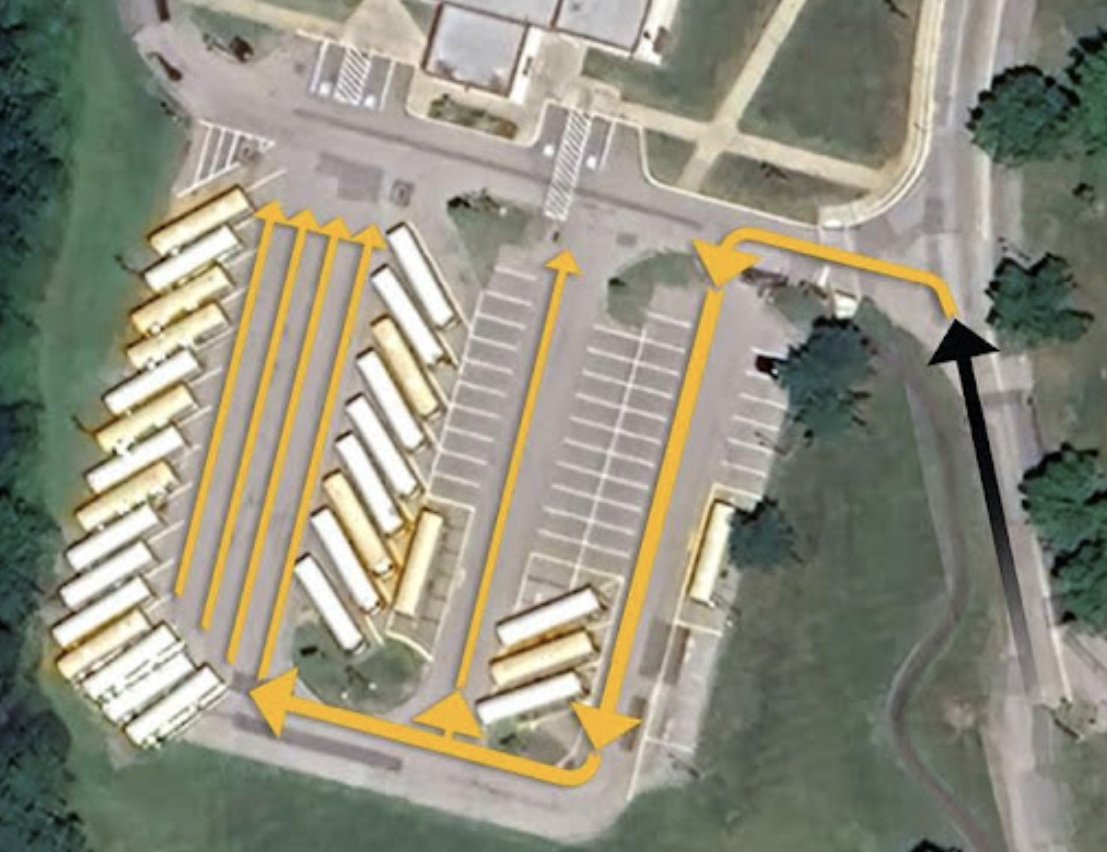Aerial map showing afternoon dismissal pick-up traffic flow in the MMS Auditorium parking lot. A black arrow indicates vehicles entering the lot, where yellow directional arrows show traffic routing through designated parking aisles and queuing into parallel staging lanes.
