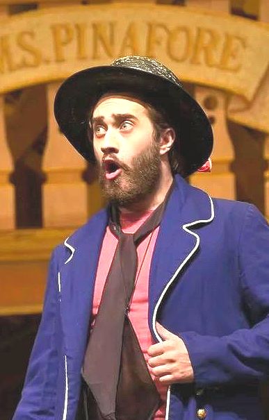Erik Tofte as Boatswain in HMS Pinafore, a bearded man singing in a sailor suit and black hat