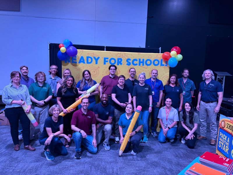 Large group posed in front of Ready For School backdrop