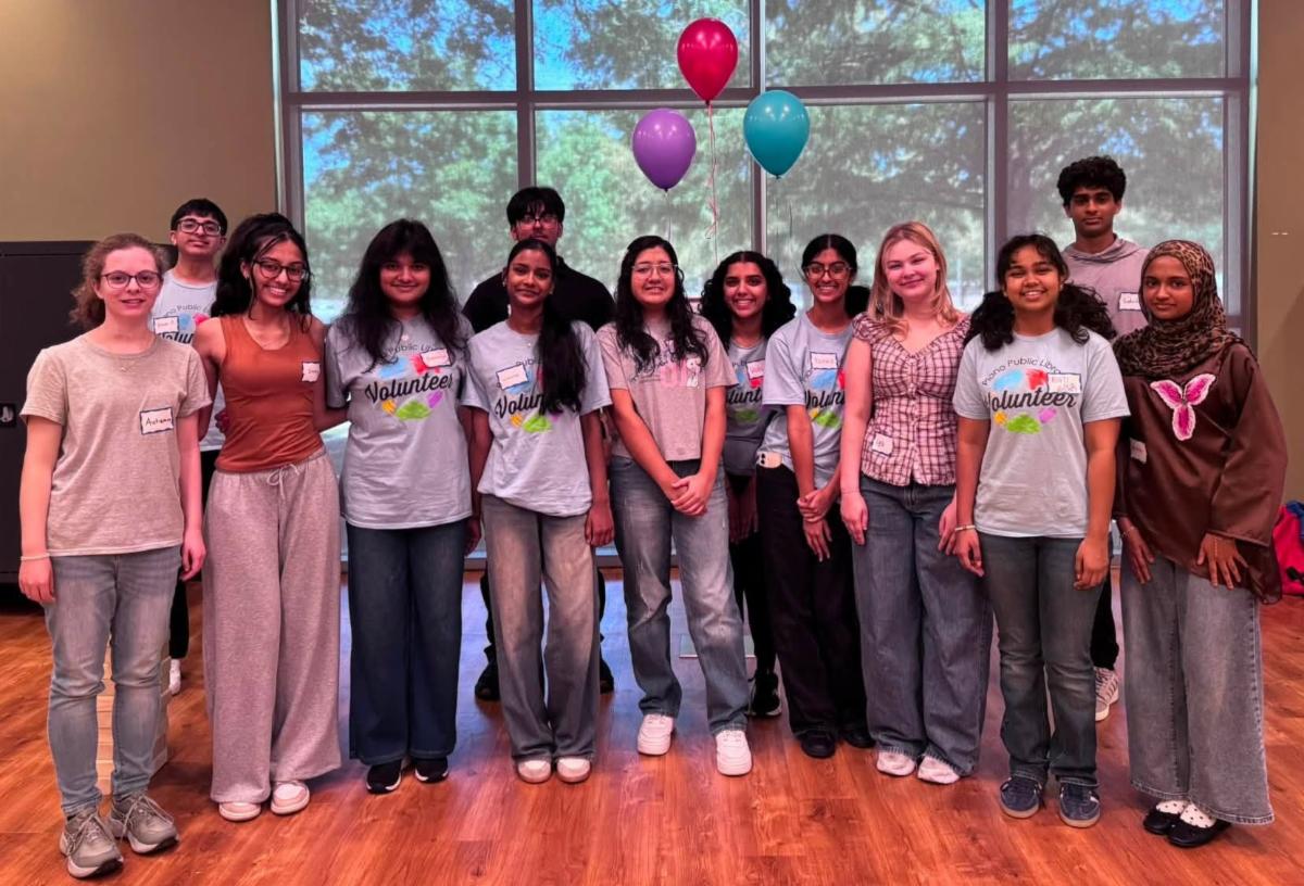 Teens posed indoors smiling with balloons in background