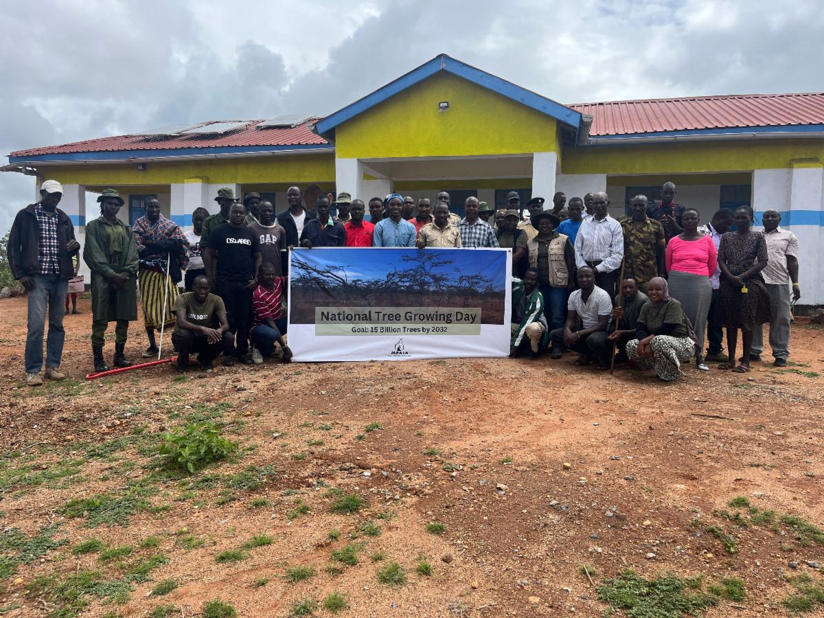 Mpala staff and members of the Lekiji community posing in front of the clinic after planting trees.