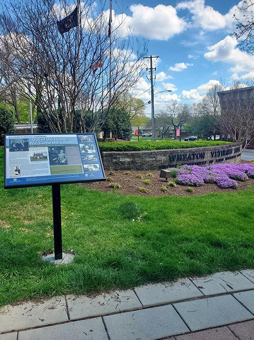 historic marker placed in grass with flowers in background
