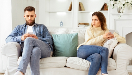 Couple Crisis. Man Using Phone_ Not Paying Attention To Wife_ Sitting On Couch