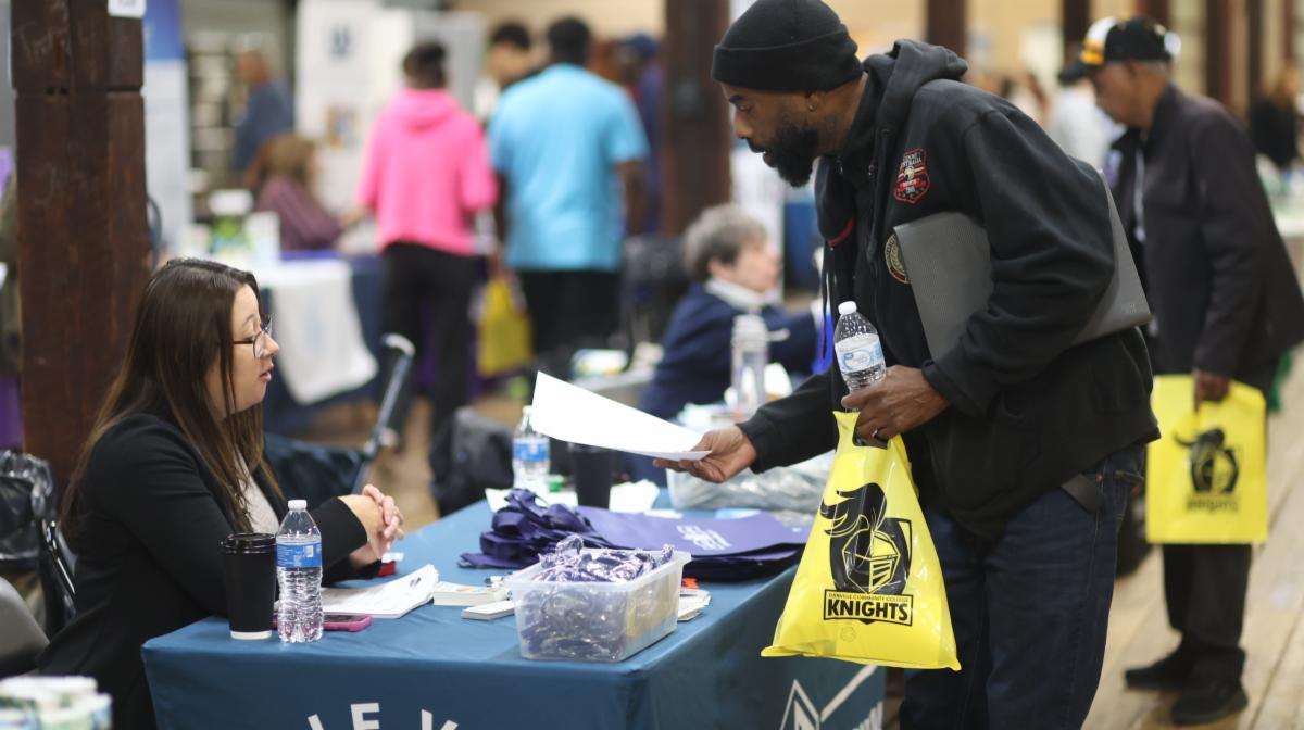 Job fair attendee talks to vendor