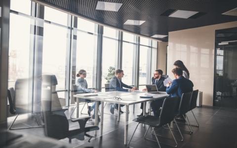 Abstract image os boardroom scene. Board members around a table behind glass