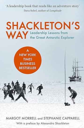 The cover of a book titled Shackletons Way Leadership Lessons from the Great Antarctic Explorer. The cover shows a group of people walking in a snowy landscape with a ship in the background. Text includes A leadership book that reads like an adventure story by Dava Sobel author of Longitude A New York Times Business Bestseller by Margot Morrell and Stephanie Caparell with a preface by Alexandra Shackleton.