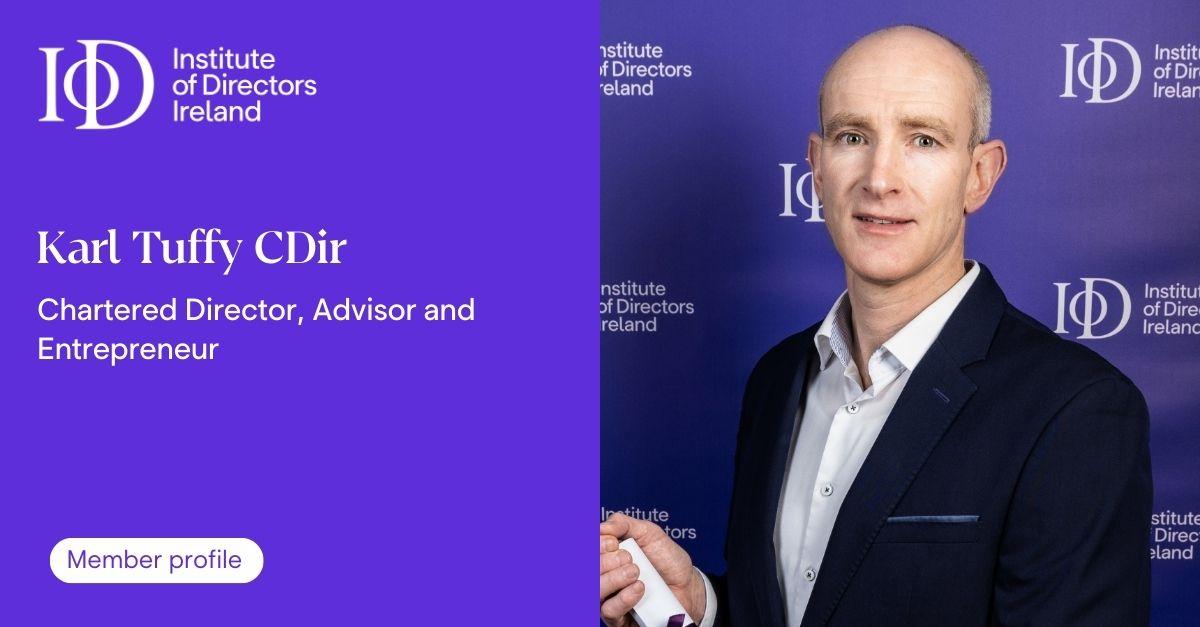 A profile graphic for the Institute of Directors Ireland. The left side shows the name Karl Tuffy CDir with the description Chartered Director Advisor and Entrepreneur and a button labeled Member profile. The right side shows a person in a dark suit standing in front of a branded Institute of Directors Ireland backdrop.