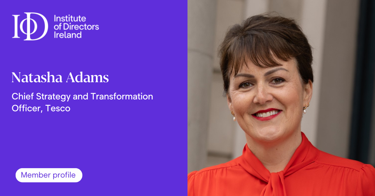 This is a profile card for Natasha Adams who is the Chief Strategy and Transformation Officer at Tesco The card is presented by the Institute of Directors Ireland The left side of the image has a purple background with white text that says Institute of Directors Ireland and Natasha Adams Chief Strategy and Transformation Officer Tesco There is a white button that says Member profile On the right side of the image there is a person wearing a red blouse.