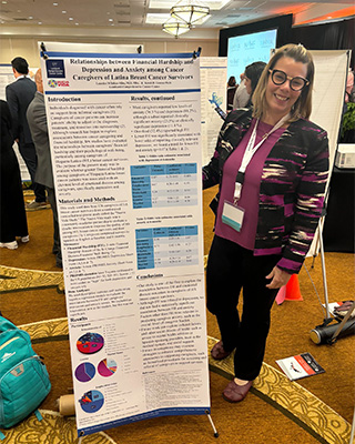 Lourdes Inbar-Albo stands with her poster at a conference