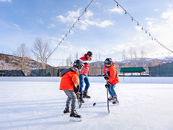 Family playing ice hockey at Snowmass