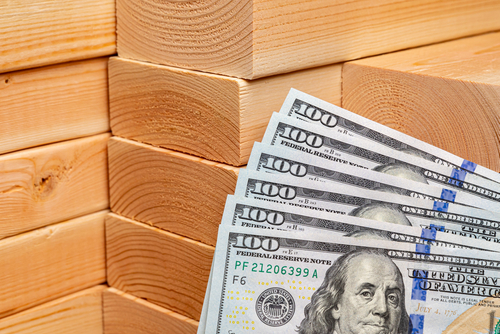 Construction lumber with cash money. Building materials price increase_ home construction and remodeling cost concept.