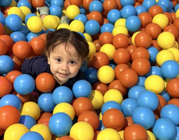 Little girl in a pile of colorful balls