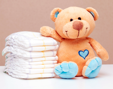 Teddy Bear with a stack of diapers