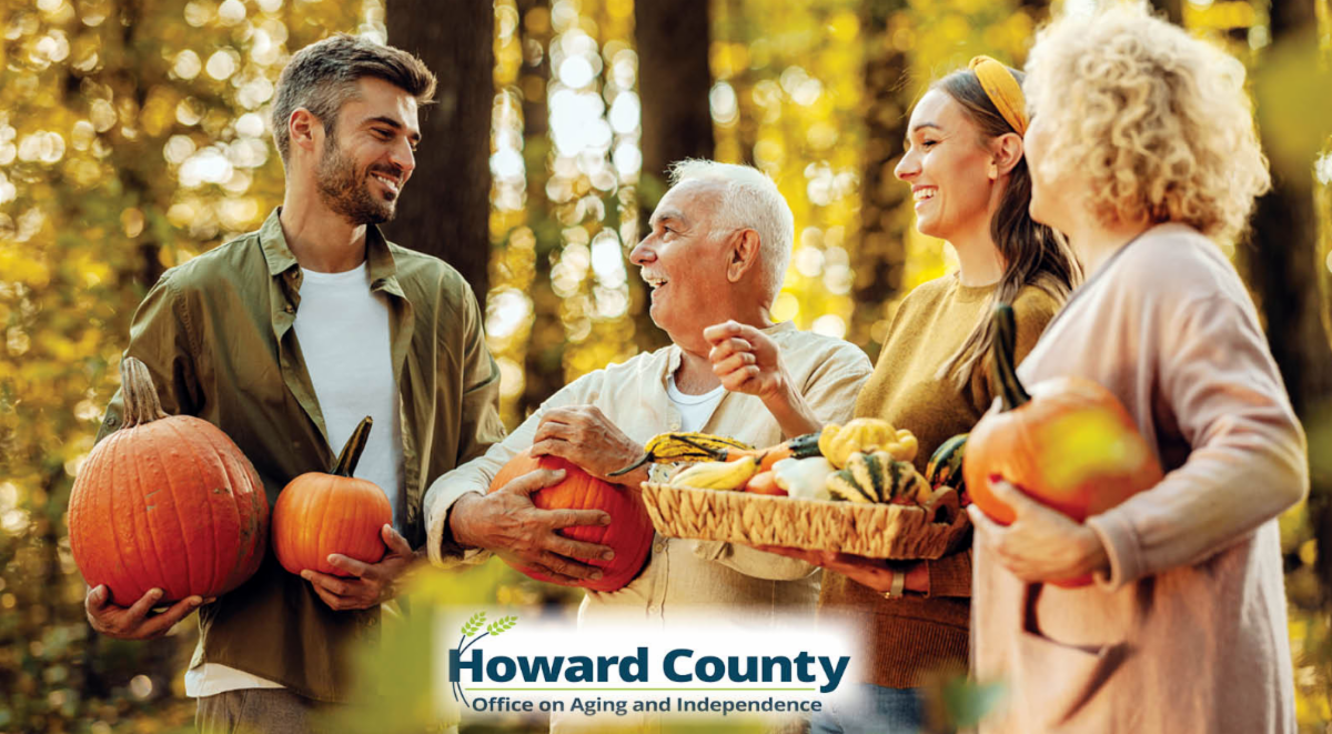 Older adults holding pumpkins