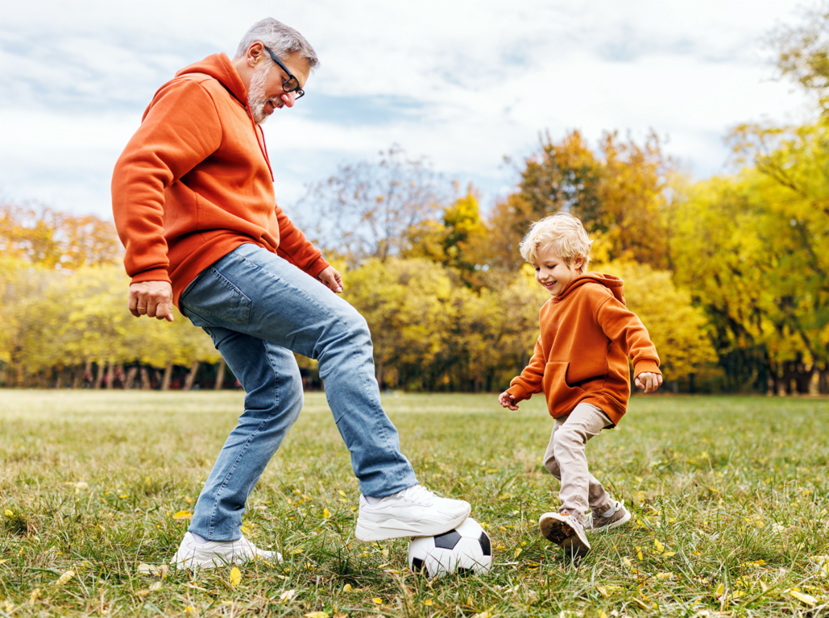 Grandfather playing soccer with his grandson
