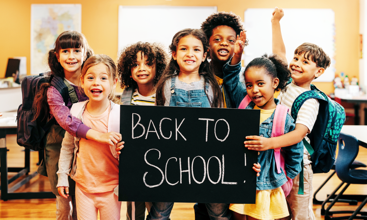 A group of children holding a back to school sign.