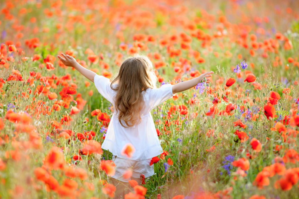 Girl dancing in a field of poppies