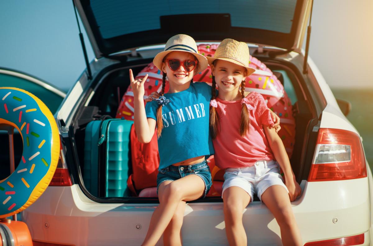 Two young girls sitting in back of a car
