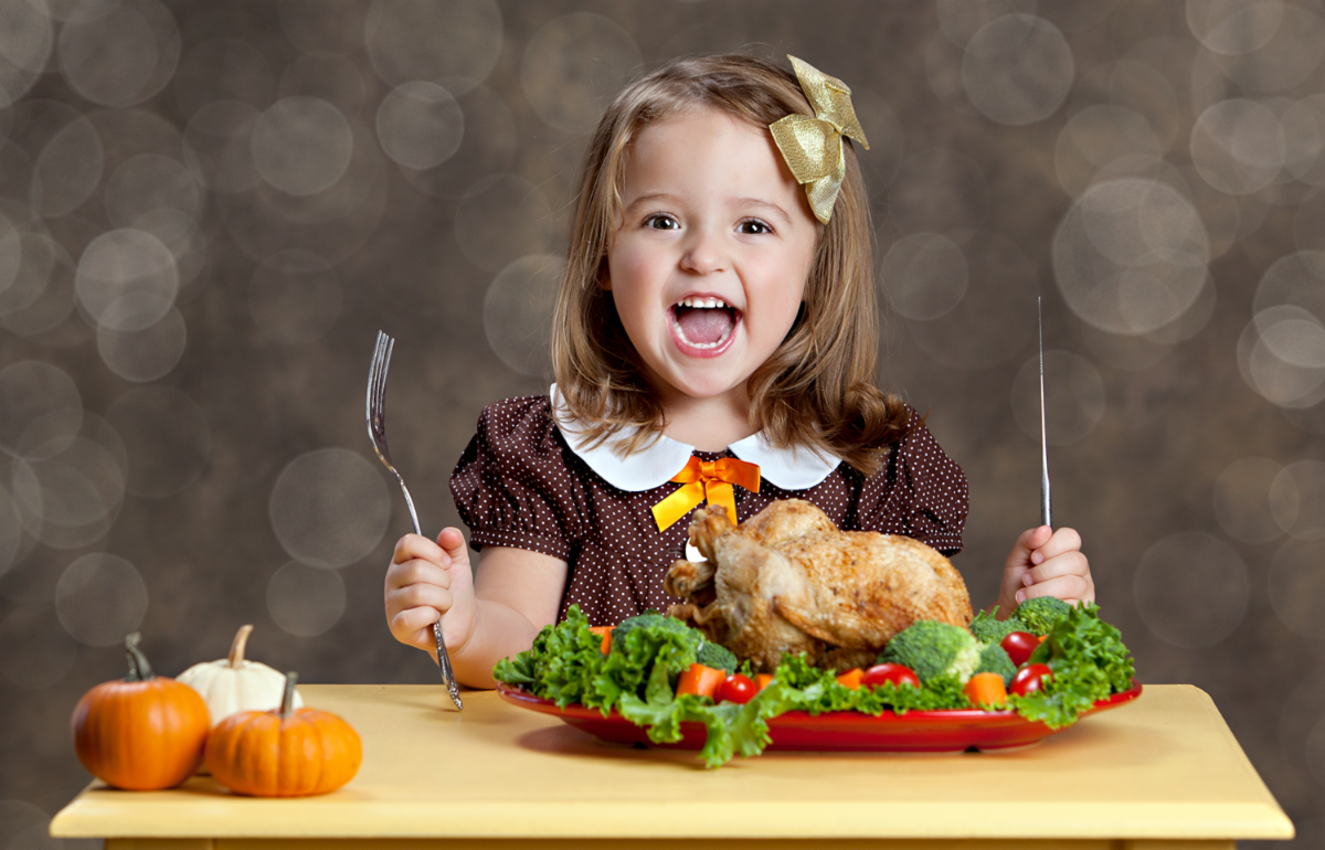 A young girl eating Thanksgiving turkey